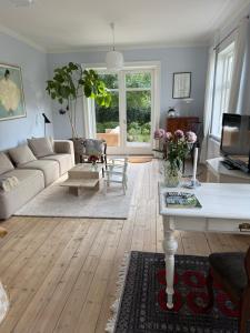 a living room with a couch and a table at Bondegård med havudsigt in Kolding +25 photos