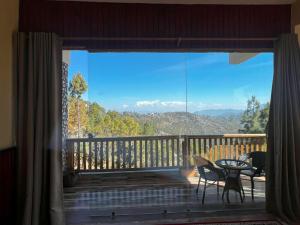 a view of a balcony with a table and chairs at Magnetic Ridge Kasar in Hawālbāgh