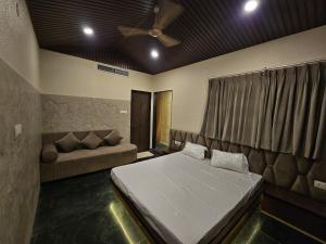 a bedroom with a bed and a couch at Mahak'sVilla in Indore