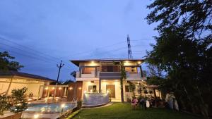 a house with people standing outside of it at night at Mahak'sVilla in Indore