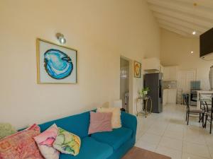 a living room with a blue couch and a kitchen at Lunar Apartments in Saint Michael