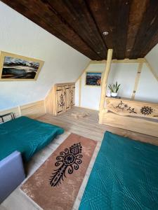 a bedroom with two beds and two rugs at Domek Gabi in Ząb