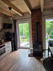 a kitchen with a woodburning stove and a patio at Na Hamaku Jacuzzi & Sauna in Marzysz