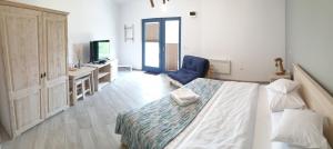 a bedroom with a bed and a blue chair at Pensiunea NEST in Dunavăţu de Jos