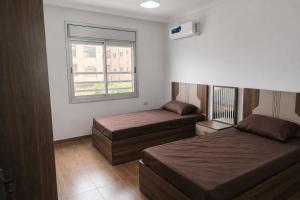 a bedroom with two beds and a window at Spacious Apartment in Amman