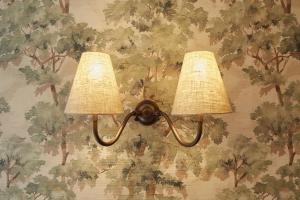 two lights on a wall with a floral wallpaper at Henriks Hotel in Copenhagen