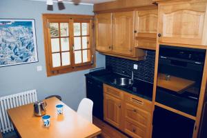 a kitchen with wooden cabinets and a wooden table at La Moussiere in Morgins