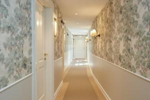 a hallway with floral wallpaper on the walls at Henriks Hotel in Copenhagen