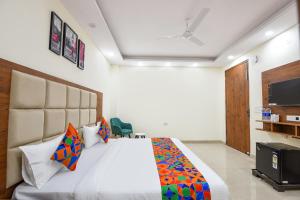 a bedroom with a large bed and a tv at FabHotel Evegreen, Faridabaad in Faridabad