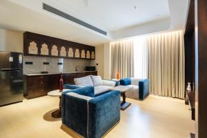a living room with two blue chairs and a table at Akaya Elegance in Ahmadnagar