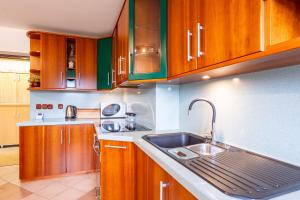 a kitchen with wooden cabinets and a sink at Apartma v ograji in Šentjernej
