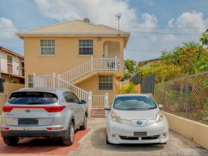 two cars parked in front of a house at Lunar Apartments in Saint Michael