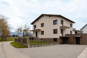a large white house with a driveway at Apartma v ograji in Šentjernej