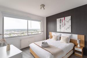 a bedroom with a large bed and a large window at L'Horizon by Cocoonr in Rennes