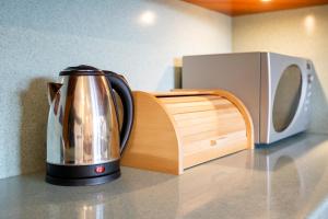 a tea kettle on a counter next to a microwave at Apartma v ograji in Šentjernej +19 photos