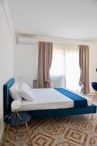 a bedroom with a large bed with blue and white sheets at Firmamento Royal House in Rocca Priora