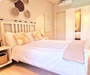 a bedroom with a large white bed with pillows at Petit Charlie @ Forest view in Banjul +18 photos