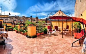 a patio with an umbrella and chairs and plants at Locanda Modigliani in Ferrara