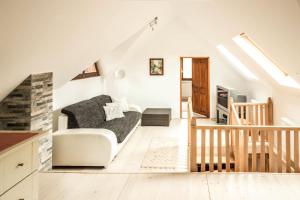 a living room with a couch and a staircase at Szőcs-birtok - The old house in Izvoare