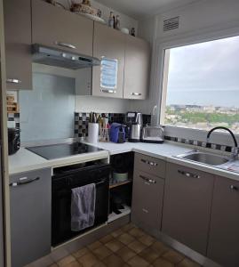 a kitchen with a sink and a stove and a window at Chambre#1privée en colocation Vue sur Paris Tour Eiffel in Cachan