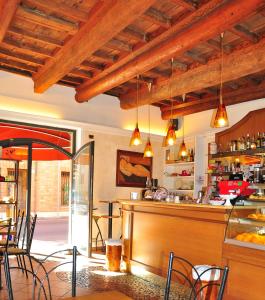 a restaurant with a bar with chairs and tables at Locanda Modigliani in Ferrara