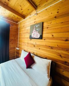a bedroom with a bed with a wooden wall at Hotel Inn morjim in Morjim