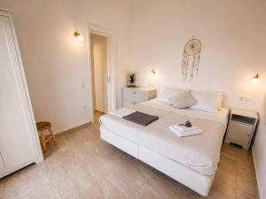 a bedroom with a large white bed with towels on it at Gaia Serifos Apartments in Rámos