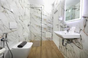 a bathroom with a toilet and a sink at Hotel HER in Vlorë +67 photos