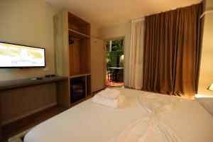 a bedroom with a bed with a flat screen tv at Hotel HER in Vlorë