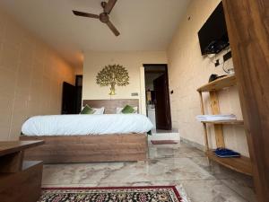 a bedroom with a bed and a ceiling fan at Magnetic Ridge Kasar in Hawālbāgh