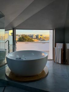 a large bath tub in a bathroom with a view at Villa Cascais Boutique Hotel in Cascais +56 photos
