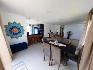 a dining room and living room with a table and chairs at Casa com piscina e hidromassagem in Ilhéus