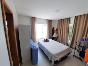 a bedroom with a bed and a large window at Casa com piscina e hidromassagem in Ilhéus +40 photos