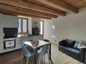 a kitchen and living room with a table and a couch at Alloggio Bellavista in Rore