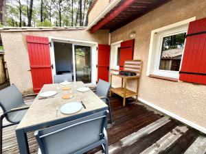 a patio with a table and chairs on a deck at Palombes 5 in Lacanau
