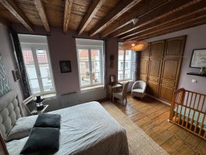 a bedroom with a large bed and windows at MAISON DE VACANCES aU 91 in Ardres