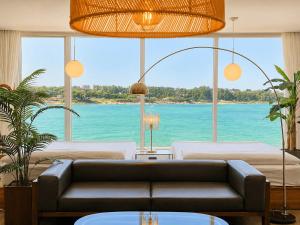 a living room with a couch and a view of the ocean at Jeju Badaneomeojip Beach Branch in Jeju
