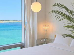 a bedroom with a bed and a large window at Jeju Badaneomeojip Beach Branch in Jeju +12 photos
