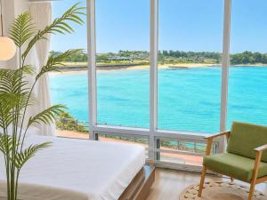 a room with a window view of the ocean at Jeju Badaneomeojip Beach Branch in Jeju