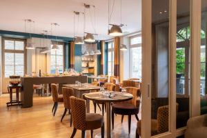 a restaurant with tables and chairs and a bar at Hôtel Le D'Avaugour in Dinan