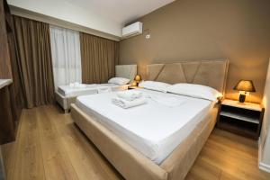 a hotel room with two beds in a room at Hotel HER in Vlorë