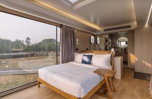 a bedroom with a bed and a large window at Anchaviyo Resort in Vāda
