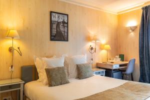 a hotel room with a bed and a desk at Hôtel Le D'Avaugour in Dinan +60 photos