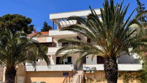 a building with palm trees in front of it at SFE Apartment in Milna