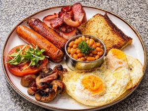 a plate of breakfast food with eggs sausage beans and toast at 19 On Bay Noakes in Harare