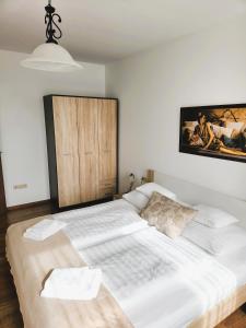 a bedroom with a large white bed with a painting on the wall at Fortuna 7 in Hévíz +46 photos