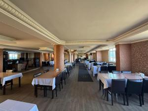 a dining room with tables and chairs with white tablecloths at Otel Ustabaş in Hopa