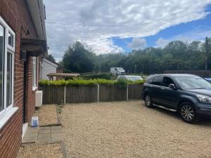 a car parked in a driveway next to a house at Wilton Manor 79 Wilton road in Feltwell