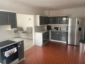 a kitchen with black cabinets and a red tile floor at Wilton Manor 79 Wilton road in Feltwell