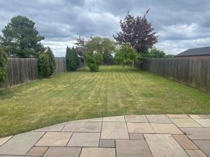 a backyard with a fence and a grass yard at Wilton Manor 79 Wilton road in Feltwell